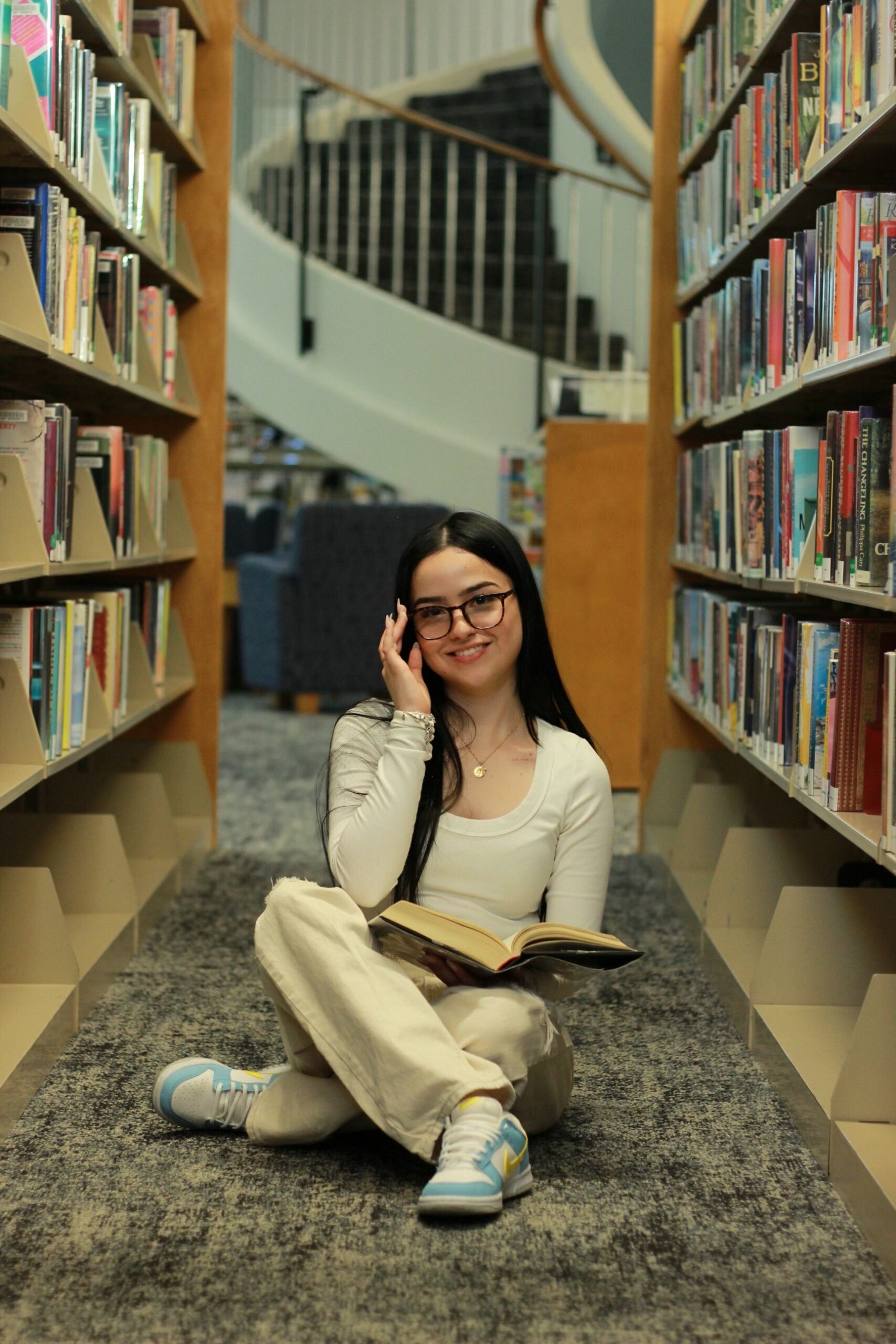 girl smiling while holding her glasses